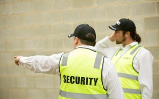Two security guards checking that a site is secure to ensure that they comply with their man guarding services duties.